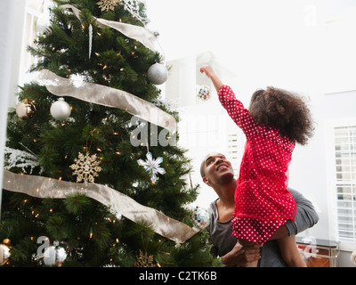 Vater und Tochter schmücken Weihnachtsbaum Stockfoto