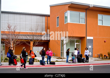 Studenten warten auf einen Bus auf Bobcat Lane außerhalb der Yablokoff-Wallace Restaurant Center an der University of California, Merced. Stockfoto