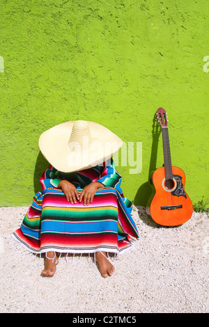 NAP faul typisch mexikanischen Sombrero Mann sitzt auf grüne Wand Stockfoto