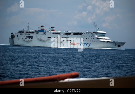 Philippinische Super Ferry befördert Passagiere über die Meere aus Puerto Galera, Mindoro, Philippinen, ebenso wie ein kleiner Banca. Stockfoto