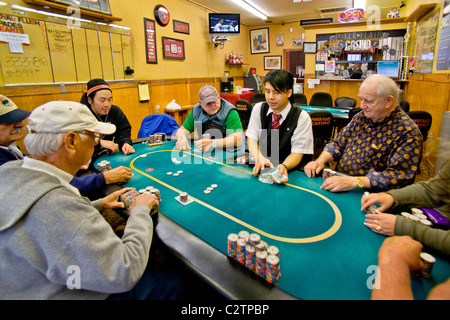 Spieler unterschiedlichen Alters und Rassen spielen Hold Poker in einem Geschäft vor Casino in Merced, Kalifornien. Stockfoto