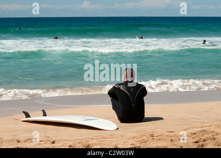 Surfer am Strand mit seinem Surfbrett, El Cotillo, Fuerteventura, Kanarische Inseln Stockfoto