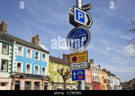 Schilder für eingeschränkte Parkplätze, Parkplatz, CCTV-Zone und Sustrans-Radweg 71 im Stadtzentrum. Cockermouth Cumbria England Großbritannien Stockfoto