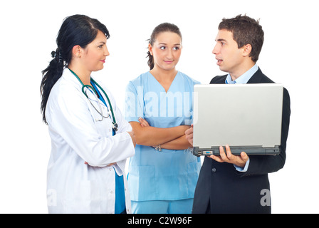 Zwei Ärzte Frauen beim Gespräch mit einem Geschäftsmann mit Laptop isoliert auf weißem Hintergrund Stockfoto