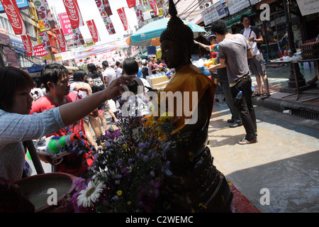 Menschen gießt Wasser über Buddha-Statue während Songkran New Year Festival an der Khao San Road in Bangkok Stockfoto