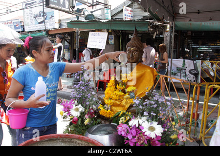 Menschen gießt Wasser über Buddha-Statue während Songkran New Year Festival an der Khao San Road in Bangkok Stockfoto