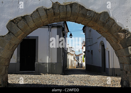 Straßen der Altstadt, durch einen Bogen von der Silber-Wasser-Aquädukt (Aqueduto Do Agua Prata) in Evora, Portugal gesehen. Stockfoto