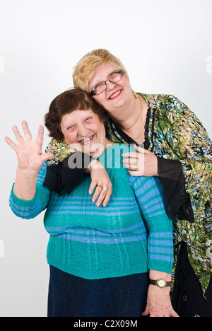 Glücklich Reife Frau Tochter umarmt ihre alte Mutter und ältere Frau Lachen und winken Stockfoto