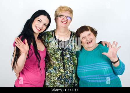 Glücklich Generationen von Frauen Großmutter, Mutter, Tochter, stehend in einer Umarmung winken und lachen Stockfoto