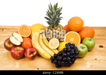 Frische Früchte aus allen Jahreszeiten auf einem Holztisch isoliert auf weißem Hintergrund Stockfoto