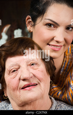 Leiter der schönen zwei Generation Großmutter und Enkelin stehen in einer Umarmung und lächelnd Stockfoto