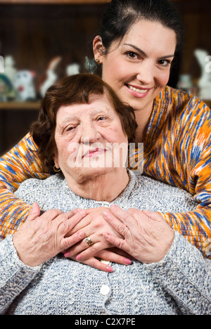 Herzliche Umarmung mit viel Liebe von einer Enkelin, die Großmutter zu Besuch ist Stockfoto