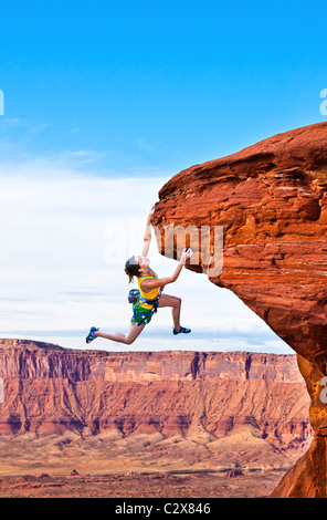 Weiblichen Rock Climber kämpft für ihre nächsten Halt auf einem anspruchsvollen Aufstieg. Stockfoto