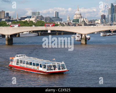 Touristen genießen Sie eine Bootsfahrt auf der Themse Waterloo Bridge mit Blick in die Stadt im Hintergrund Stockfoto