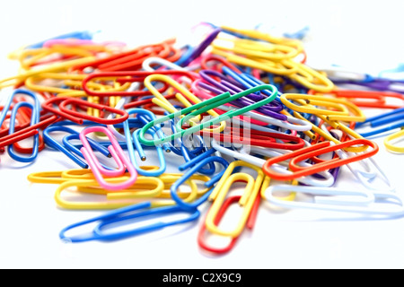 Viele bunte Büroklammern auf weißem Hintergrund. Stockfoto