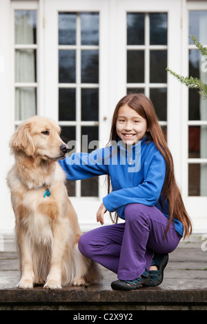 Gemischte Rassen Mädchen streicheln Golden retriever Stockfoto