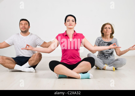 Gruppe von Menschen, die Yoga machen und sitzen auf dem Boden Stockfoto