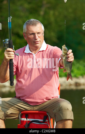 Foto von senior woman Fang von Fischen am Wochenende Stockfoto