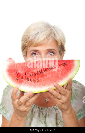 Ältere Frau mit einer Scheibe Wassermelone neben ihrem Gesicht isoliert auf weißem Hintergrund Stockfoto