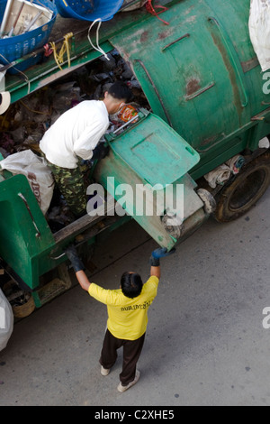 Zwei Männer sind ein Müllwagen mit Müll auf einer Stadtstraße in Mae Sai, Thailand (Sae) laden. Stockfoto