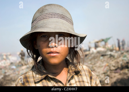 Ein Junge im Alter von Kind Arbeiter Schulmädchen sucht Wertstoffe auf einer Mülldeponie Pollutred in Kambodscha. Stockfoto