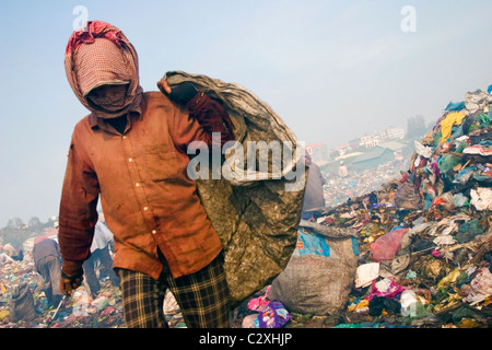 Eine Frau, die in Armut lebenden Menschen ist auf der Suche nach Kunststoff auf einen verschmutzten und toxische Müllhalde in Kambodscha. Stockfoto