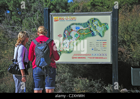 Paar auf der Suche auf Karte von Wai-O-Tapu Thermal Wonderland, Rotorua, Bucht von viel Region, Nordinsel, Neuseeland Stockfoto