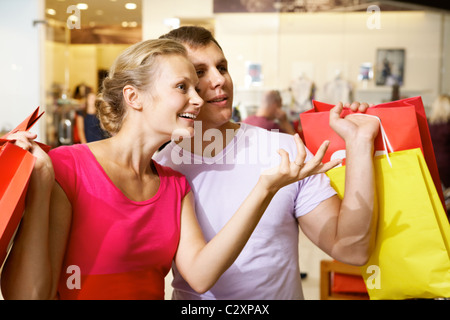 Eine Frau, die etwas zu ihrem Mann im Supermarkt Stockfoto