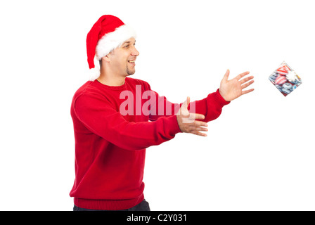 Happy Santa Helfer Mann mit Bart versucht, ein kleines Geschenk in Bewegung isoliert auf weißem Hintergrund zu fangen Stockfoto