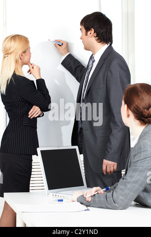 Zeichnen einen Plan auf einem Whiteboard für seinen Kollegen Geschäftsmann Stockfoto