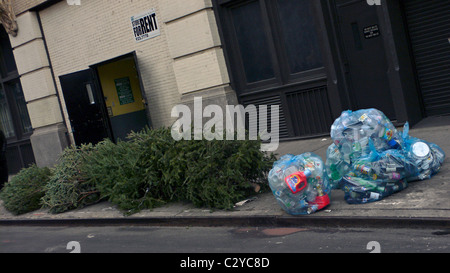 Weihnachtsbäume und erlegten Recycleables auf Bordstein für die Abholung von Müll Schlepper Winkel Detritus Müll Müll Stockfoto