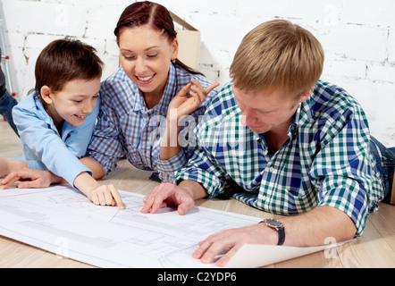 Junge Familie diskutieren Plan der neuen Wohnung Stockfoto