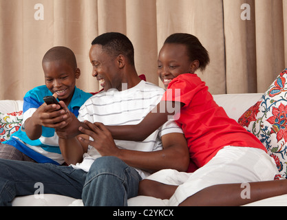 Mann und Kinder kämpfen über Fernbedienung, Johannesburg, Südafrika Stockfoto