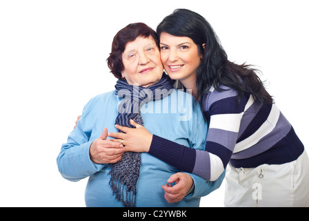 Schöne Enkelin und Großmutter stehen in einer Umarmung und lächelnd isolierten auf weißen Hintergrund Stockfoto