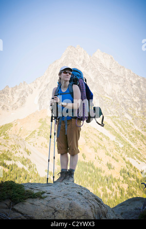 Frau mit schweren Rucksack auf posiert vor dem Mount Stuart in den zentralen Kaskaden von Washington State, USA. Stockfoto