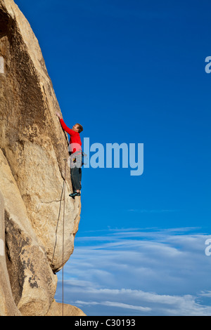 Männliche Felsen Kletterer kämpft für seinen nächsten Griff auf einem anspruchsvollen Aufstieg. Stockfoto