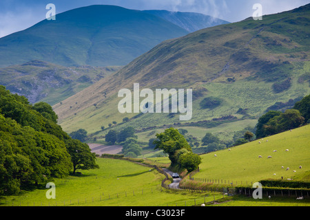 Auto fahren auf kurvenreichen Straße durch malerische Tal bei Llanfihangel, Snowdonia, Gwynedd, Wales Stockfoto