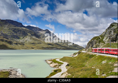 Der Glacier Express Zug schlängelt sich um die felsigen Berge Seen der Schweiz Stockfoto