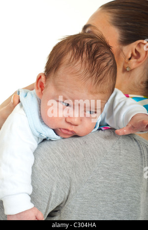 Porträt des Neugeborenen sechs Wochen alt auf die Schulter seiner Mutter vor weißem Hintergrund Stockfoto