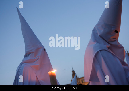 Mit Kapuze Büßer (Nazarenos) im Kerzenlicht-Prozession während Sevillas jährliche Karwoche (Semana Santa de Sevilla) Stockfoto