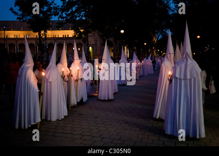 Mit Kapuze Büßer (Nazarenos) im Kerzenlicht-Prozession während Sevillas jährliche Karwoche (Semana Santa de Sevilla) Stockfoto