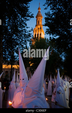 Mit Kapuze Büßer (Nazarenos) im Kerzenlicht-Prozession während Sevillas jährliche Karwoche (Semana Santa de Sevilla) Stockfoto