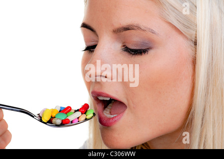 Frau mit vielen Pillen auf einem Löffel Stockfoto