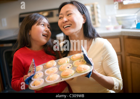 Asiatische Mutter und Tochter Backen Muffins in der Küche zu Hause Stockfoto