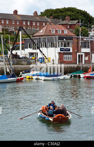 Kleines Boot rudern über Wemyouth Hafen, Dorset, England, Großbritannien Stockfoto