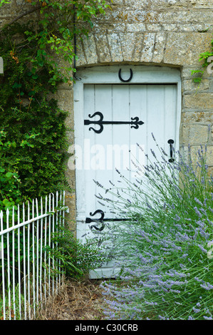 Lavendel-Busch und traditionelle Hütte Eingang in die Cotswolds Dorf Bledington, Oxfordshire, Vereinigtes Königreich Stockfoto