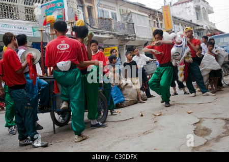 Kind Arbeiter Kinder Leben in Armut (Zentrum & rechts) beobachten ein Chinese New Year fest auf einer Straße in Kambodscha. Stockfoto