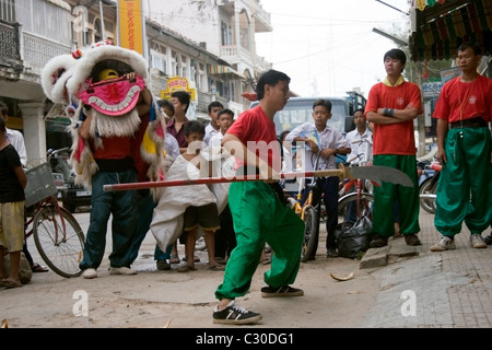 Eine Gruppe von Menschen, darunter auch Straßenkinder, beobachten ein Chinese New Year fest auf einer Stadtstraße in Kambodscha. Stockfoto