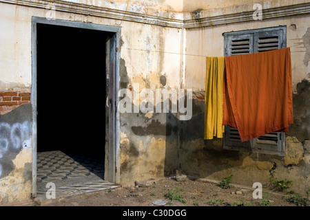 Orange-buddhistischer Mönch Roben hängen auf einer Wäscheleine an einem verfallenen Tempel in Kambodscha. Stockfoto