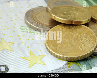 Euro: Münzen liegen auf 100 Euro-Banknote Stockfoto